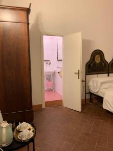Schlafzimmer mit einem Bett und einer Tür, die zu einem Bad führt in der Unterkunft Casa Cerboneschi in Casale Marittimo