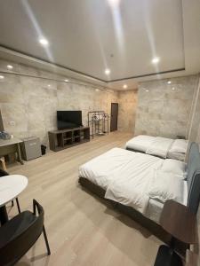 a bedroom with a bed and a flat screen tv at 新化61行館民宿 