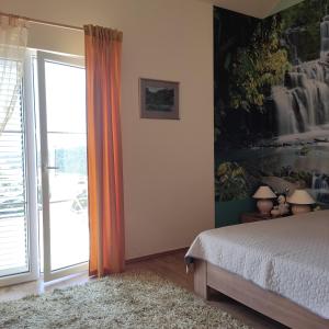 a bedroom with a bed and a sliding glass door at Suntime Villa 7 in Tivat