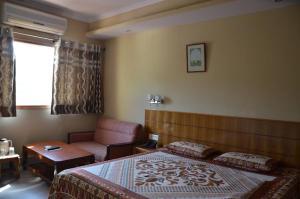 帕拉姆普爾的住宿－Hotel Starry Night，一间卧室配有一张床、一张沙发和一张桌子