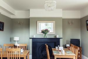 a dining room with a fireplace and a table and chairs at The Caledon Guest House in Cowes