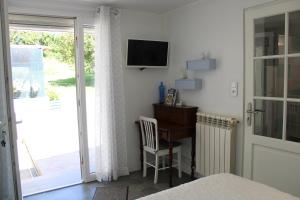 a bedroom with a desk and a television on a wall at chambre d'hôte au calme absolu in Lectoure