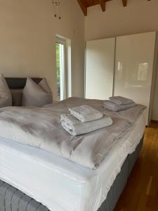 Una cama blanca con dos toallas encima. en Stilvolle Ferienwohnung in ruhiger Lage en Willingen