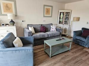 a living room with two couches and a coffee table at Rosehip Cottage in Somerton