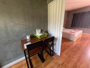 a room with a desk and a bed and a table and chair at Studio Apartment w/ Kitchen in Thalang in Phuket Town