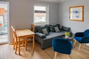 a living room with a couch and a table at CBlue "Apartmenthaus Chrischanshof" in Warnemünde