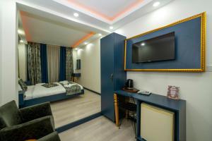 a room with a blue wall with a tv and a bed at Sweet Home in Istanbul