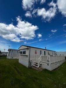 a mobile home with a porch on a grass field at Seaview Holiday Rentals - Seawall in Whitstable