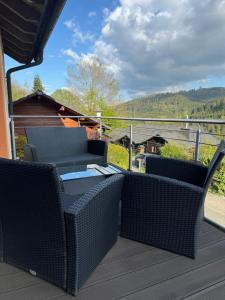 un patio con sillas y mesas en una terraza en Stilvolle Ferienwohnung in ruhiger Lage en Willingen