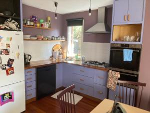 kuchnia z fioletowymi szafkami i czarną lodówką w obiekcie Preston Accommodation- beautiful quiet room w Melbourne