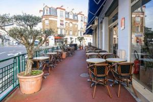 una fila de mesas y sillas en una acera en Le Val D'or & Le Theatre, en Suresnes