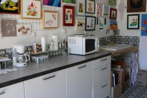a kitchen with a counter top with a microwave at chambre d'hôte au calme absolu in Lectoure