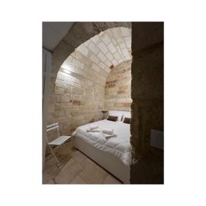 a bedroom with a bed in a brick wall at Locus Amoenus in Polignano a Mare