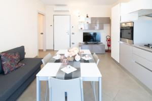 a kitchen and a living room with a table and chairs at Seventyfive House in Chioggia