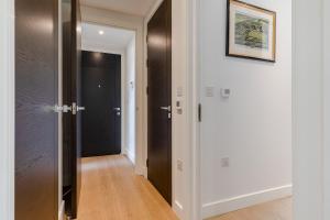 倫敦的住宿－StayInn Aldgate，走廊上设有白色的墙壁和黑色的门