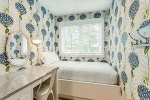 a bedroom with blue and white wallpaper with a bed and a mirror at Lakemore Resort in Traverse City
