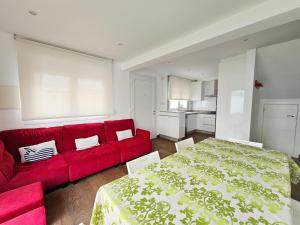 a red couch and a red bed in a room at Casa del Arenal - Laxe in Laxe