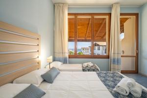 - une chambre avec 2 lits et une fenêtre dans l'établissement Cala Della Torre Resort, à La Caletta