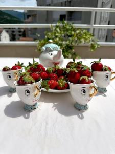a plate of strawberries on a table with two bowls at Apartmani Simona in Budva