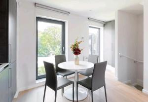 Deluxe Central London North Apartment في لندن: غرفة طعام مع طاولة بيضاء وكراسي