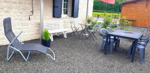 a table and chairs and a bench in a yard at LE CLOS DES PRAIRIES Suite 2 grandes chambres in Saint-Yan