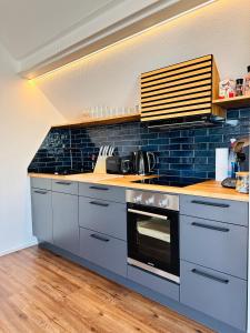 a kitchen with a stove and blue tiles at Villa Dana Bodensee in Friedrichshafen