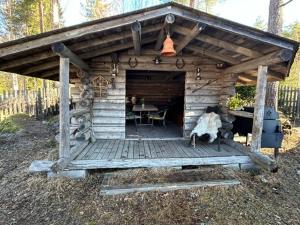 a wooden cabin with a table and a dining room at Pihasauna Mökki - Villa Alpaca Laamatila in Nokia
