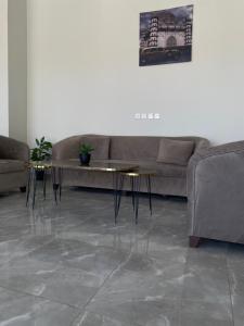 a living room with a couch and two tables at أجنحة دارك للشقق المخدومة - Ajnihat Dark Serviced Apartments in Ad Dawādimī