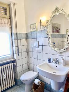 een badkamer met een wastafel, een toilet en een spiegel bij B&B Casa Dolce Casa in Verona