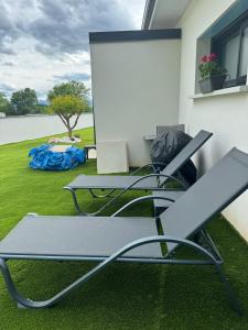 a patio with two chairs and a table on the grass at studio Lauralex in Montardon