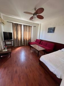 un soggiorno con divano rosso e TV di Rawche 30 Apartments a Beirut