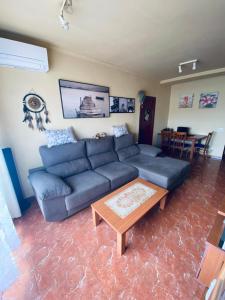 sala de estar con sofá azul y mesa en Completa y Amplia Habitación a 10 minutos de la playa Casa Compartida, en Algaida