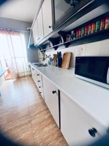 una cucina con armadietti bianchi e pavimenti in legno di Completa y Amplia Habitación a 10 minutos de la playa Casa Compartida a Algaida
