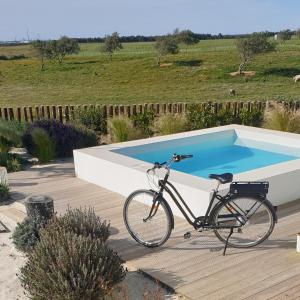 una bicicleta estacionada junto a una piscina en Casa Calmar, en Porto Covo
