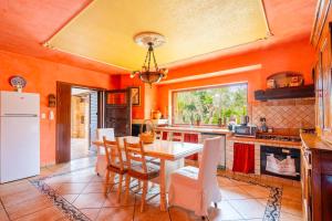 a kitchen with orange walls and a table and chairs at Villa Tiziana in Castrignano del Capo