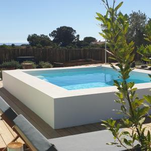 a swimming pool in a backyard with a wooden fence at Casa Calmar in Porto Covo
