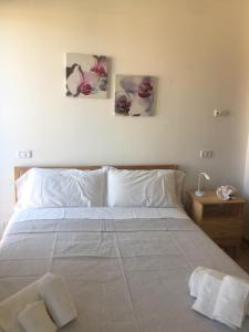 una camera da letto con un letto con tre dipinti sul muro di Ne parliamo Stasera a Porto Santo Stefano