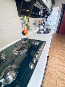 a stove top in a kitchen with a sink at Completa y Amplia Habitación a 10 minutos de la playa Casa Compartida in Algaida