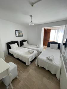 a room with two beds and a table at Bedesten Pansiyon in Çeşme