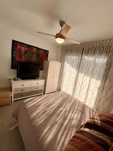 Schlafzimmer mit einem Bett und einem Flachbild-TV in der Unterkunft SHR052 Marinsa Beach Apartment in Morche
