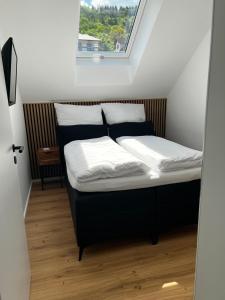 Ferienwohnung Weitblick في كوشيم: سرير في غرفة صغيرة مع نافذة