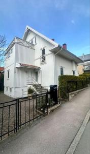 a white house with a fence in front of it at Superhomes 1 gäst in Gothenburg