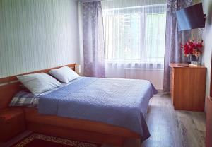 a bedroom with a bed and a window at EMVIKA apartament in Šiauliai