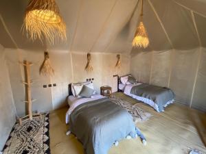 Postel nebo postele na pokoji v ubytování Merzouga Luxury Sahara Camps
