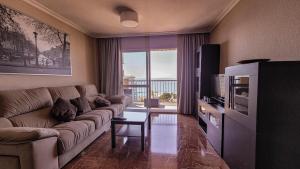 Una sala de estar con un sofá y un televisor. en Apartamento Don Gustavo Attic, en Benalmádena