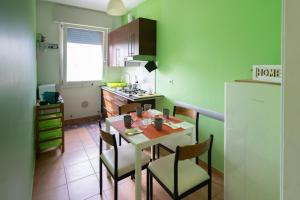 a kitchen with a table and chairs in a kitchen at SUN House in Chioggia
