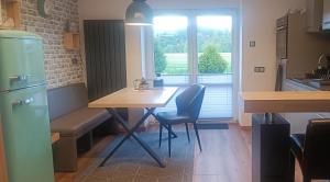 eine Küche mit einem Tisch und Stühlen sowie einem Fenster in der Unterkunft Haus MaRi in Niederwiesa