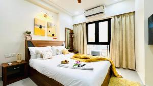 a bedroom with a bed with a tray of food on it at BluO Stylish 2BHK New Town Rajarhat - Skyline View Condo in Kolkata