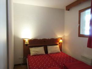 阿爾維厄的住宿－Les granges d'Arvieux vue sur le Queyras，一间卧室配有红色的床和2个白色枕头
