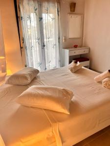 ein großes weißes Bett mit zwei Kissen und einem Fenster in der Unterkunft Dreams Beach Apartments Katelios in Kateliós